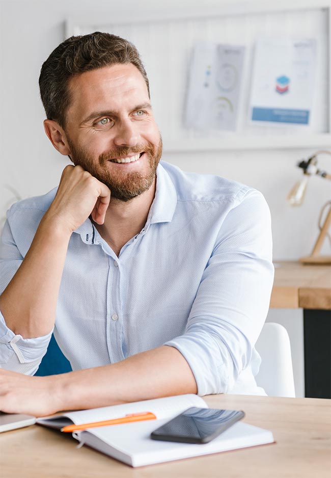 Happy bearded man sitting in office working 5HT4XK3